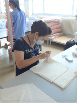 中国工場で、商品のタオルを検品する田澤恵津子さん