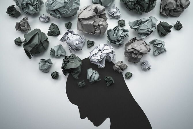 丸めた紙と頭のシルエット、不安と否定的な感情の概念イメージ