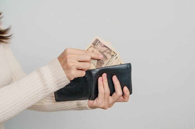 財布と1万円札を持つ女性の手