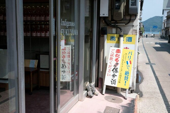 八田保命酒舗の外観。道の先に「仙人が酔うほど美しい」とうたわれる仙酔島が見える