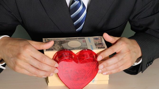 札束とハートを持つビジネスマン