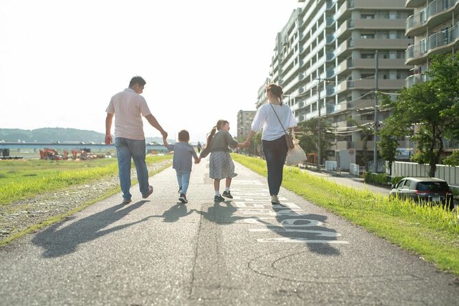 手をつないで一緒に歩く家族