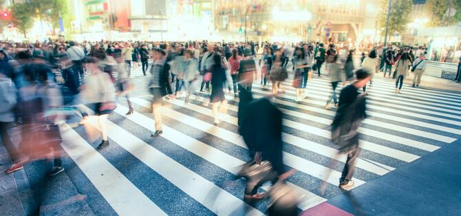 都会の交差点を行き交う人々