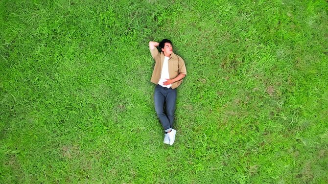 芝生の上に横になっている男性