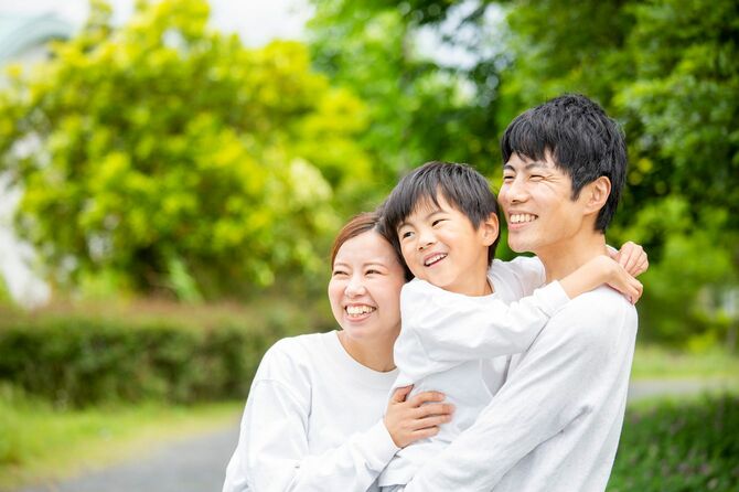 公園で笑顔を見せる若い家族