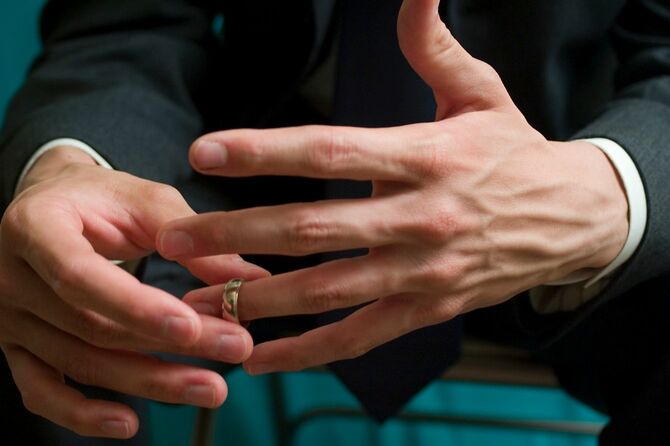 結婚指輪外そうとしているか、付けようとしている男性の手元