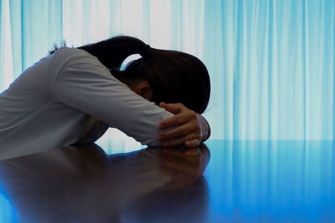 テーブルに伏せる女性