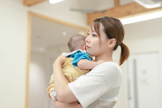 赤ん坊を腕に抱いている女性