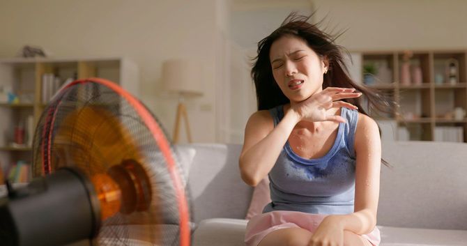 扇風機を使用する女性