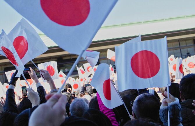 新年のお祝いと天皇の誕生日に日本の国旗を振る人々