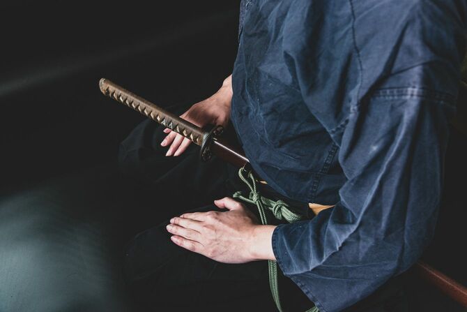 長物を差し、正座する男性