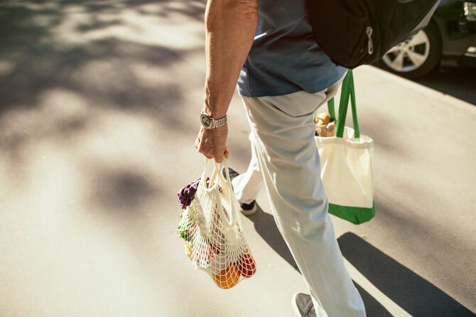 エコバッグに購入した食料品などを入れて持って歩いている男性