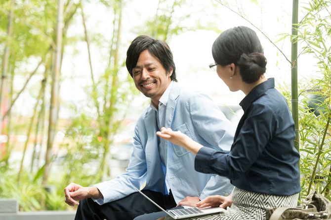 京都で屋外でラップトップを働く2人の日本のビジネスプロフェッショナル