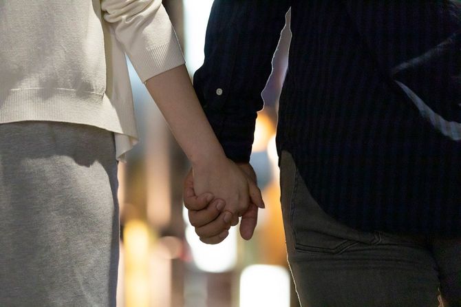 手をつないで歩く男女
