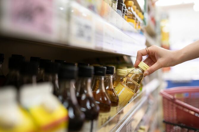 商品棚から瓶を手に取る手元