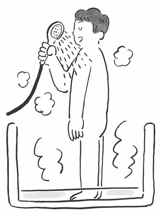 少しお湯を張った浴槽に足をつけながらシャワーを浴びる人