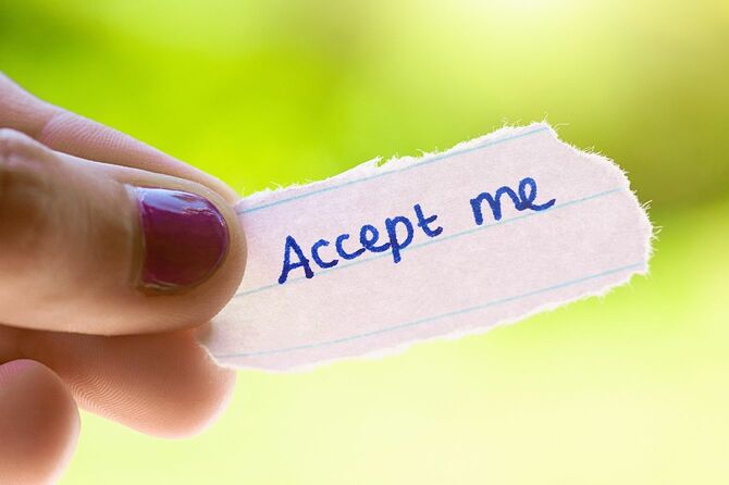 「Accept me」と書いてあるメモを持つ手