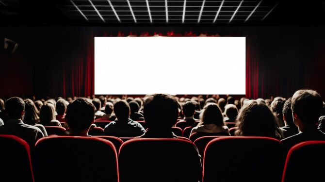 映画館で白いスクリーンを見る人々