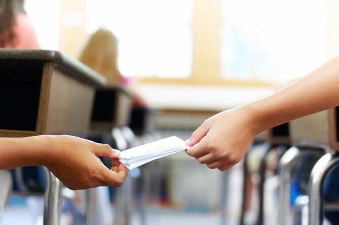 授業中にこっそりお互いにメモを渡す2人の学校の子供たち