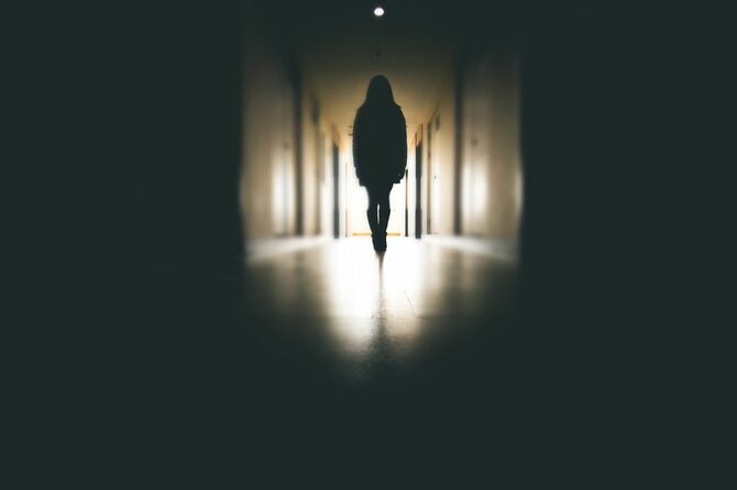 暗い廊下を歩いている女性のシルエット