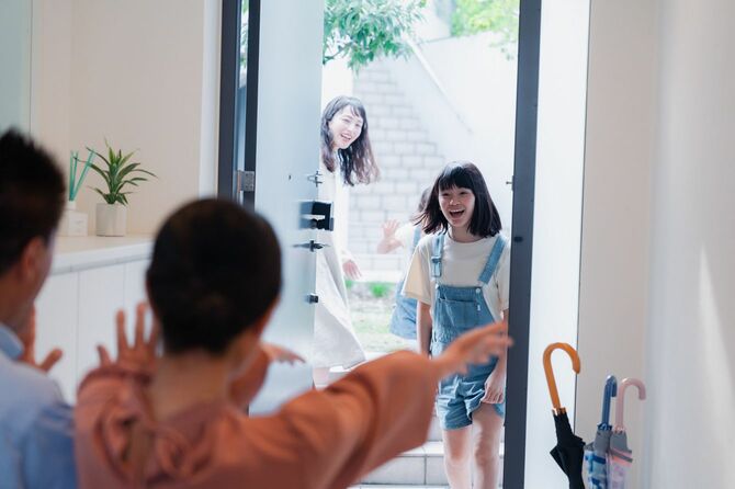 玄関扉を勢いよく開けた孫を歓迎する祖父母