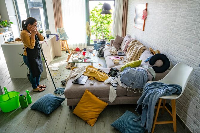 いざ掃除をしようとして、あまりの乱雑さに困惑している女性