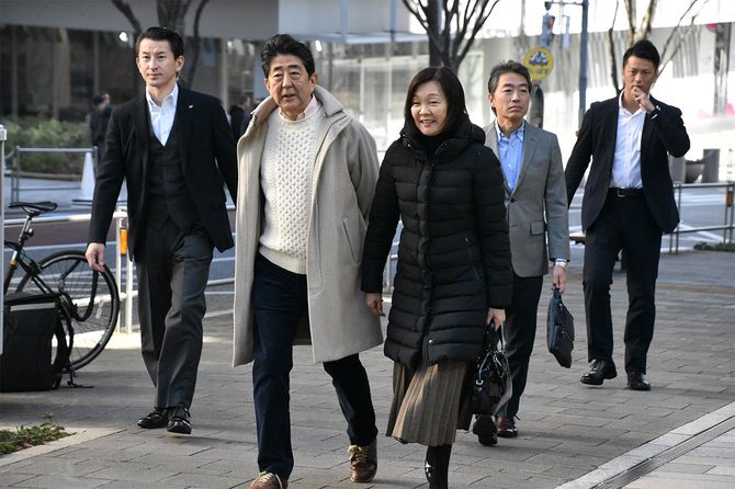 静養先のホテル周辺を散歩する安倍晋三首相（左から2人目）と昭恵夫人（同3人目）＝2019年12月31日、東京・六本木