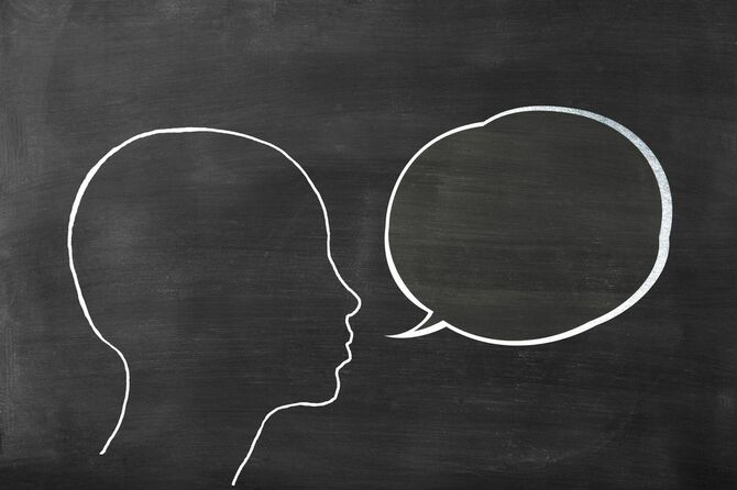 黒板にチョークで描かれたヒトの頭部と吹き出し