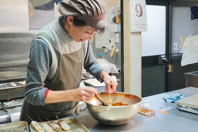 お客さんの対応をしながら団子を焼いて、忙しそうに働く昭美さん
