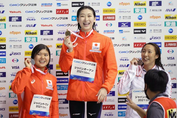 女子100メートルバタフライで優勝し笑顔を見せる池江璃花子（中央、ルネサンス）。左は2位の長谷川涼香（東京ドーム）、右は3位の相馬あい（ミキハウス）＝6日、千葉県国際総合水泳場