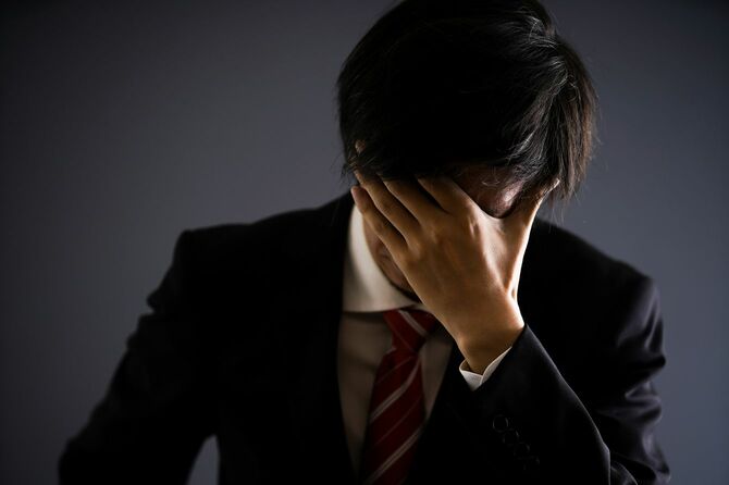 頭を抱えている男性