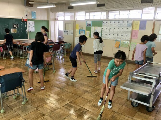小学校の教室で、児童たちが清掃中