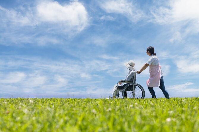 青空の下を散歩する2台の車椅子