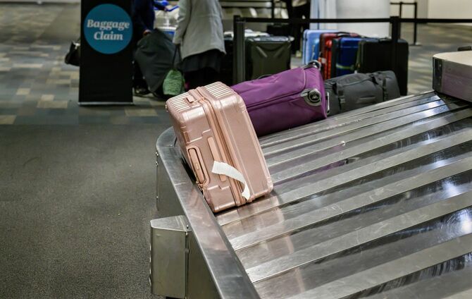 空港の手荷物受取所のコンベアをまわっているスーツケース