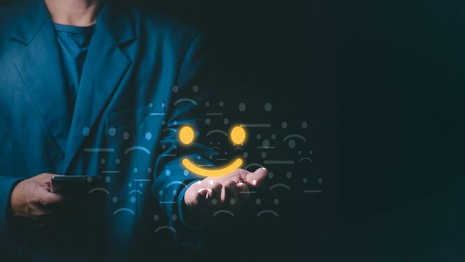 ビジネスマンの手のひらに乗った笑顔のアイコン