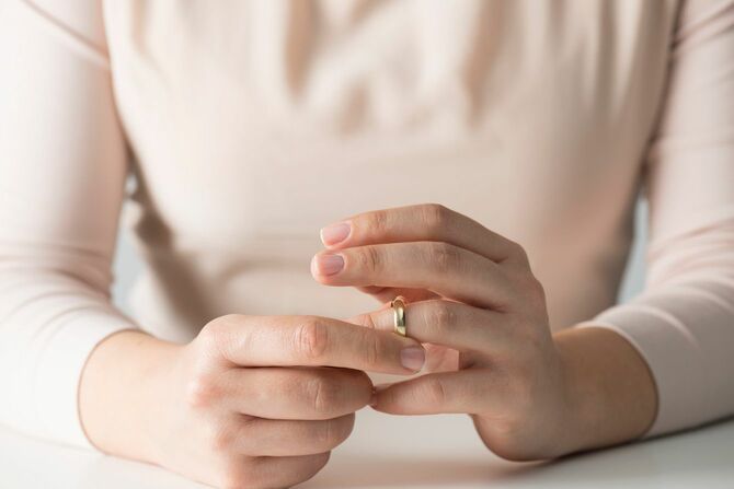 結婚指輪を外す女性の手元
