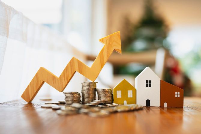 家の模型、コイン、上向きの矢印