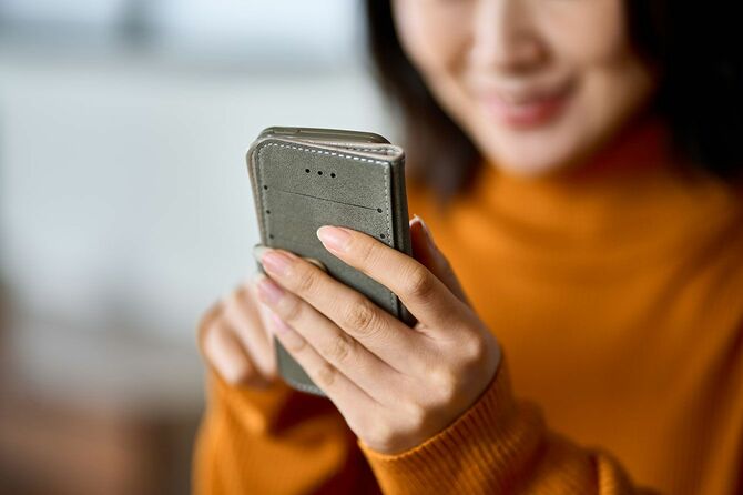 笑顔でスマホを使用している女性