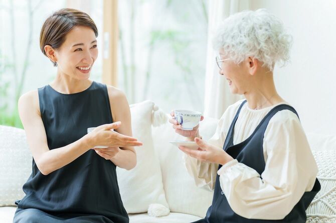 お茶を飲みながら笑顔で話す二人の女性