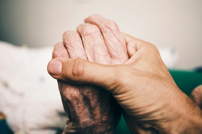 高齢者の手を握る