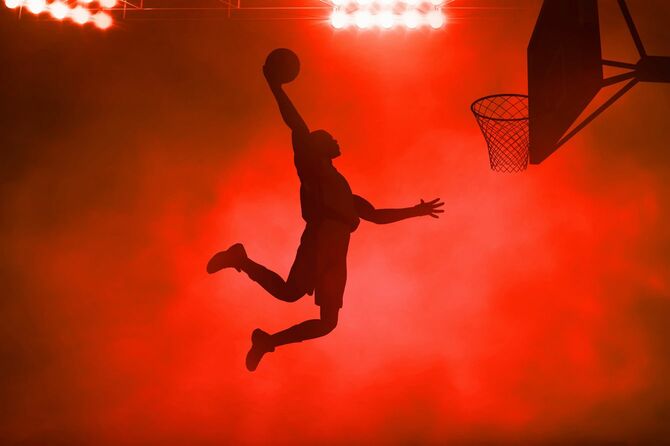 ダンクシュートを決めようとしている男性のシルエット