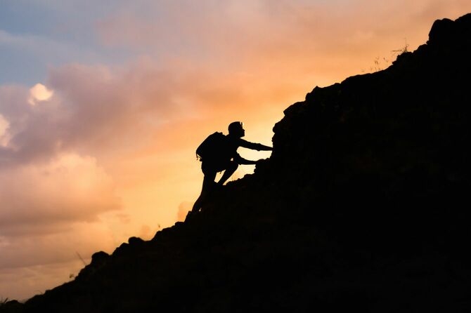 急な山を登る男性ハイカー