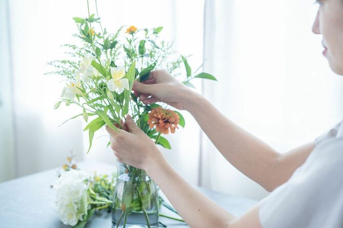 花瓶に花を挿す女性