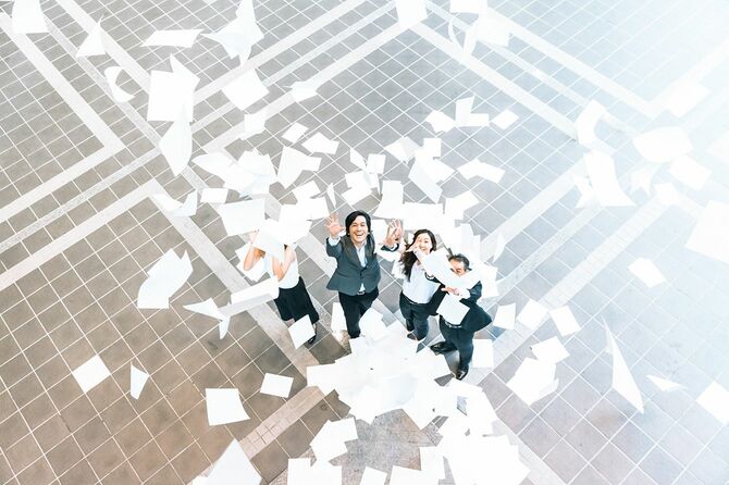 降ってくる紙をつかもうとする人たち