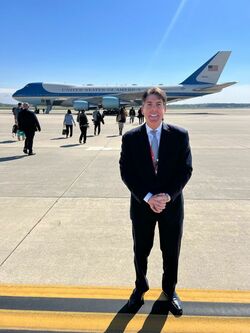 大統領に同行取材する際のジョン・デッカー（Jon Decker）さん。背景にアメリカ大統領専用機エアフォースワンが見える