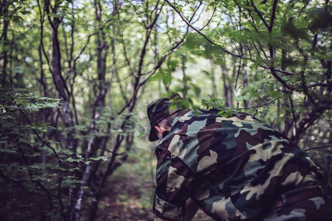 迷彩服で森に潜む兵士