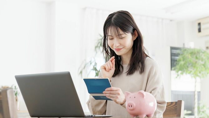 通帳を見て笑顔の女性