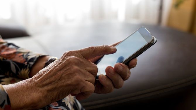 高齢女性が携帯電話を持つ手元のアップ