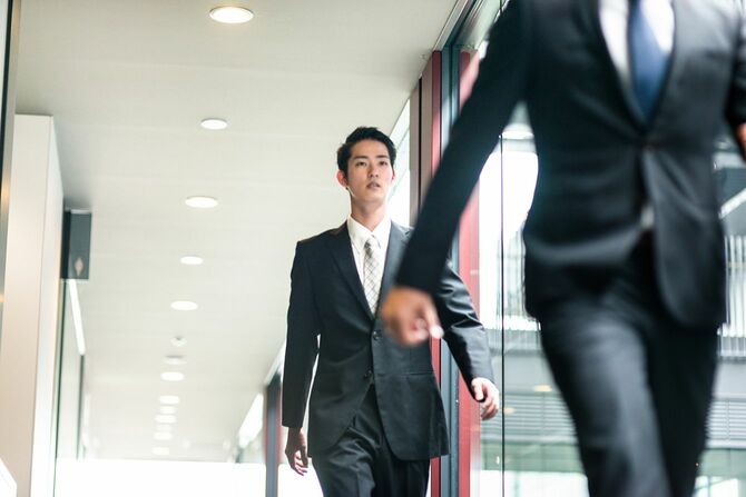 会社の通路を歩く男性