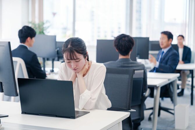 オフィスのデスクで我慢している女性